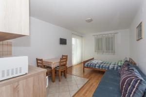 een keuken en een woonkamer met een bank en een tafel bij Apartments Mršić in Biograd na Moru