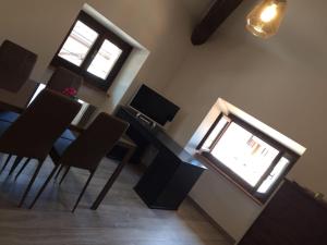 a dining room with a table and chairs and two windows at Antica Contrada Marocco in Riva del Garda