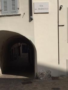 um edifício branco com um sinal na lateral em Antica Contrada Marocco em Riva del Garda