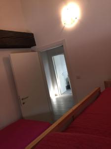 sypialnia z lustrem, łóżkiem i drzwiami w obiekcie Antica Contrada Marocco w mieście Riva del Garda +14 zdjęć