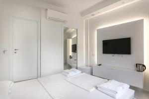 ein weißes Wohnzimmer mit einem Flachbild-TV an der Wand in der Unterkunft Al Molo Sea View Rooms in Lerici