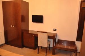 a room with a desk and a television on a wall at Guesthouse Dolinsek in Sevnica