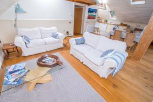 a living room with two white couches and a glass table at The Garden Studios in Budleigh Salterton