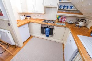 a small kitchen with white cabinets and wooden floors at The Garden Studios in Budleigh Salterton