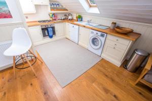 a kitchen with a sink and a washing machine at The Garden Studios in Budleigh Salterton