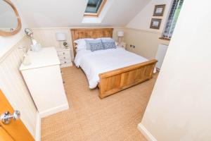 a small bedroom with a bed and a mirror at The Garden Studios in Budleigh Salterton