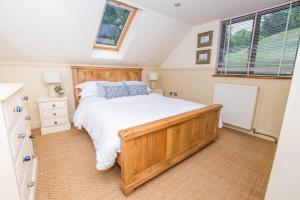 a bedroom with a large wooden bed and a window at The Garden Studios in Budleigh Salterton