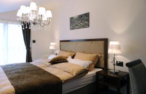 a bedroom with a large bed with a chandelier at Guesthouse Dolinsek in Sevnica +51 photos