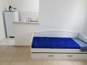 Bett mit blauer Bettwäsche in einem Zimmer mit Waschbecken in der Unterkunft Apartamento no Dalas Park Residencial in Campina Grande