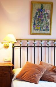 a bed in a bedroom with a picture on the wall at Hotel Hontoria in Hontoria