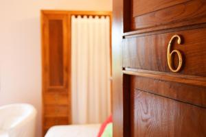 a bedroom with a wooden door with the number six at Hotel Hontoria in Hontoria