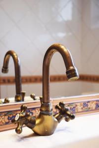 a bathroom sink with a brass faucet at Hotel Hontoria in Hontoria +37 photos