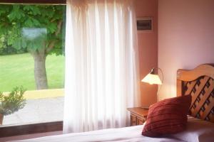 a bedroom with a bed and a window with a tree at Hotel Hontoria in Hontoria