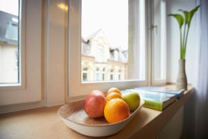 uma taça de fruta numa mesa ao lado de uma janela em Aparthotel TU-TU em Essen