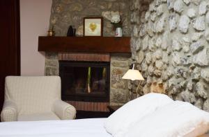 a bedroom with a fireplace and a bed and a chair at Hotel Hontoria in Hontoria