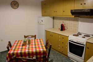 cocina con mesa, fogones y nevera en Petros Family, en Agios Ioannis