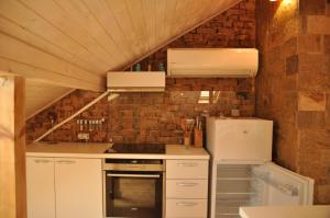 a kitchen with white appliances and a brick wall at Ema Artistic House in Pleven