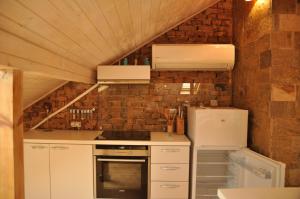 eine Küche mit weißen Geräten und einer Ziegelwand in der Unterkunft Ema Artistic House in Plewen