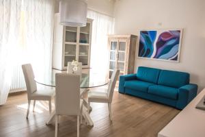 uma sala de estar com uma mesa de vidro e um sofá azul em Appartamenti San Pietro em Perugia