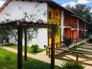 una casa de color amarillo y blanco en Apartamento em Lençóis Serrano 101, en Lençóis