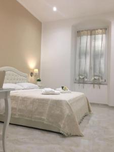 a white bedroom with a bed and a window at Queen Chic Apartment in La Spezia