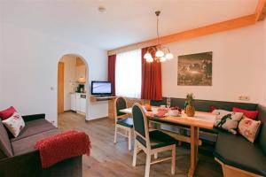 ein Wohnzimmer mit Tisch und Couch in der Unterkunft Apart Faldershof in Fiss