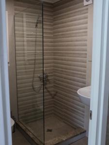 a shower with a glass door in a bathroom at Liberty Apartment And Rooms in Tbilisi City