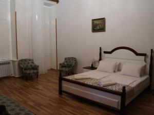 a bedroom with a bed and two chairs at Liberty Apartment And Rooms in Tbilisi City