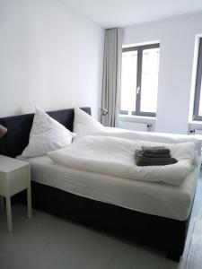 ein Schlafzimmer mit einem großen Bett mit weißer Bettwäsche und einem Fenster in der Unterkunft Ferienwohnung zum Burgtor in Lübeck