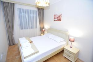 um quarto com uma cama branca e uma janela em ROOMS & APARTMENTS DOBROTSKI DVORI em Kotor