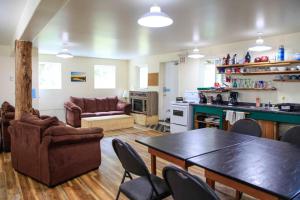 a kitchen and living room with a table and chairs at C&N Backpackers - Ucluelet in Ucluelet