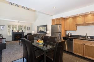 a kitchen and living room with a table and a couch at Glacier Lodge Resort in Whistler