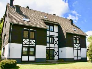 a large house with black and white trim at Poppenberg Lodge in Winterberg