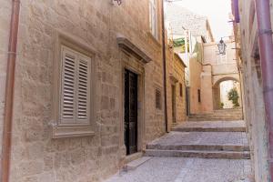 an alley with stairs and a door in a stone building at Lausion Apartments in Dubrovnik