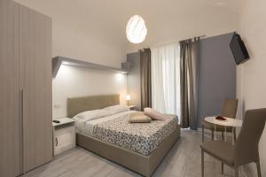 ein Schlafzimmer mit einem Bett, einem Tisch und einem Stuhl in der Unterkunft San Peter Angels in Rom