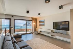 a living room with a couch and a television at Tossa de Mar Beach in Tossa de Mar