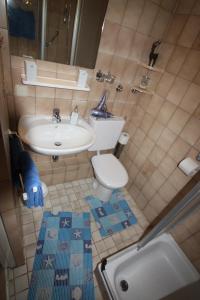 a small bathroom with a sink and a toilet at Armarova Ihre Ferienpension in Cuxhaven +68 photos