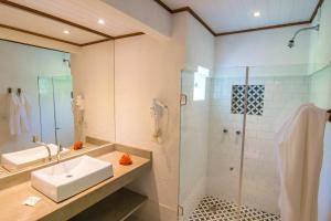 a bathroom with a sink and a shower at Manacá Pousada Parque in Arraial d'Ajuda