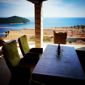 uma mesa com uma garrafa de vinho e duas cadeiras em Old Town & Sea View em Dubrovnik