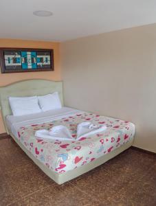 a bedroom with a bed with two shoes on it at Hotel Boquilla Suites By GEH Suites in Cartagena de Indias