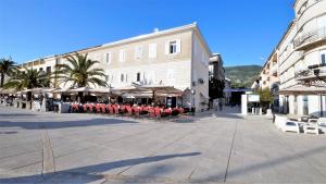 a street with chairs and umbrellas in a town square at Kala Lux Apartment in Tivat