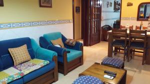 a waiting room with two blue chairs and a table at Ti Laura Praia in Praia da Barra