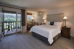a bedroom with a large bed and a balcony at Wine Country Inn Napa Valley in St. Helena
