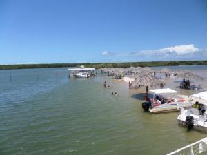 a beach with umbrellas and people on the water at Apto Praia Atalaia in Aracaju