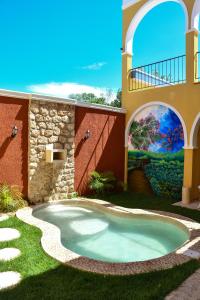 una piscina en el patio de una casa con una pintura en Casa Sisal Valladolid Yuc, en Valladolid