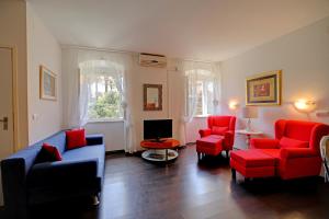 a living room with red chairs and a tv at Apartment La Vida in Dubrovnik