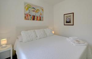 a white bed in a bedroom with a painting on the wall at Apartment La Vida in Dubrovnik