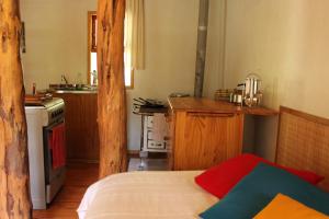 a room with a kitchen with a bed and a stove at Remanso Andino in Palena
