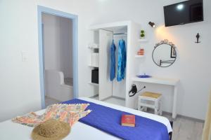 a bedroom with a bed with blue sheets and a mirror at Vasealis & Seafis Sirma Klima in Klima
