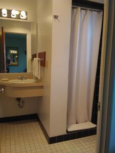 y baño con cortina de ducha y lavamanos. en Bay Bridge Motel, en North Bend